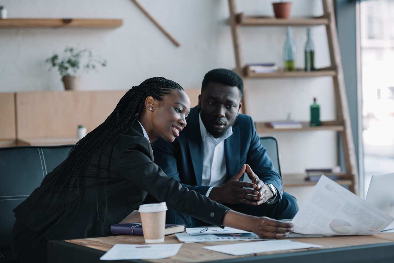 african american businesspeople discussing new business project in cafe